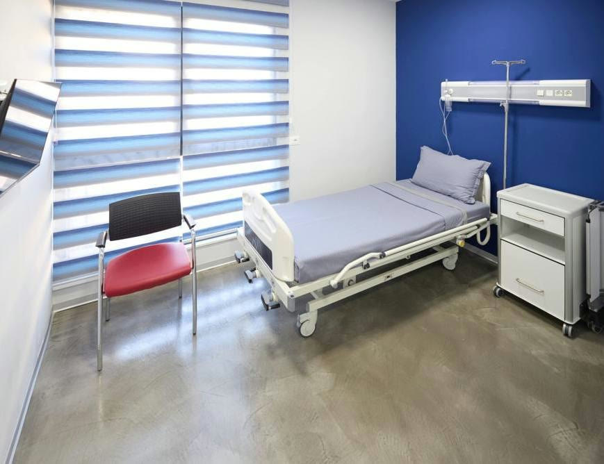 A private recovery room at SAGA Clinic with a bed and an armchair