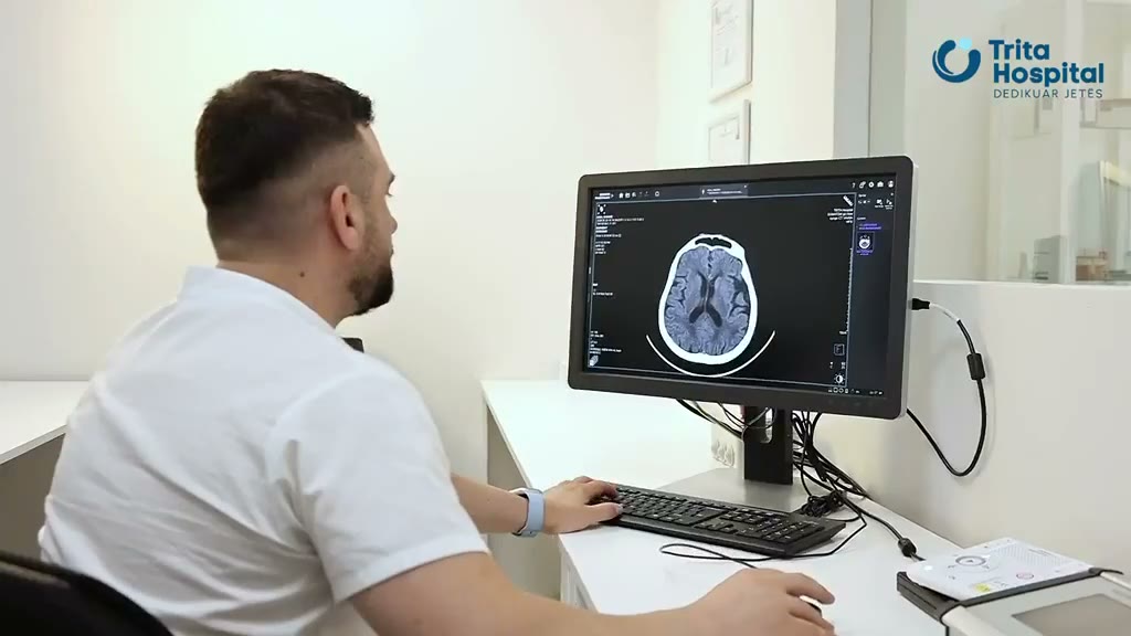 A clinician at Trita Hospital reviewing a brain scan on a monitor